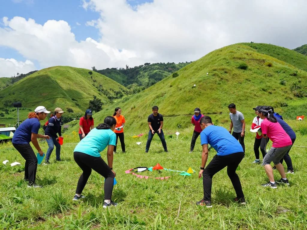 Outbound Jogja group engaging in team-building activities in scenic hills.